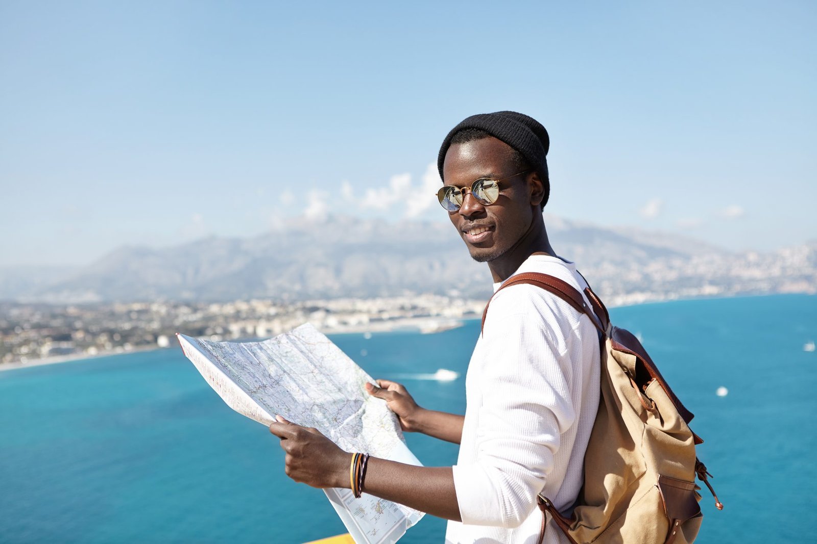 Voyageur observant une ville côtière espagnole avec une carte