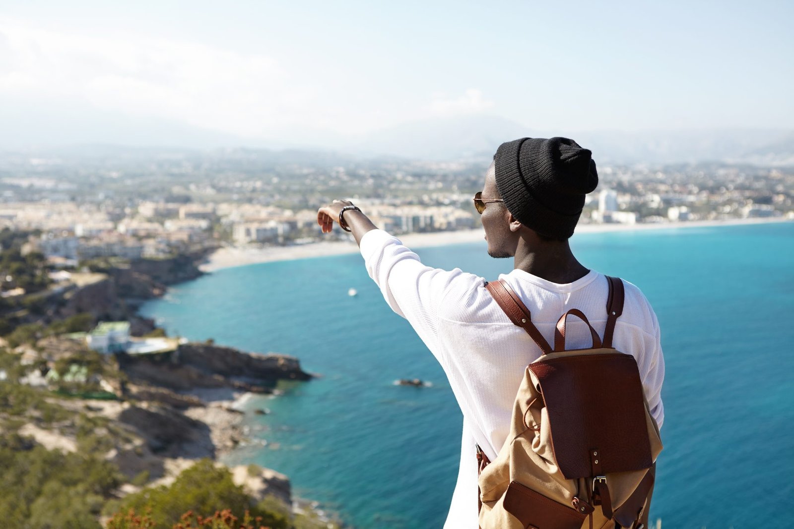 Candidat africain regardant vers l'horizon d'une ville côtière espagnole, prêt pour son projet de mobilité